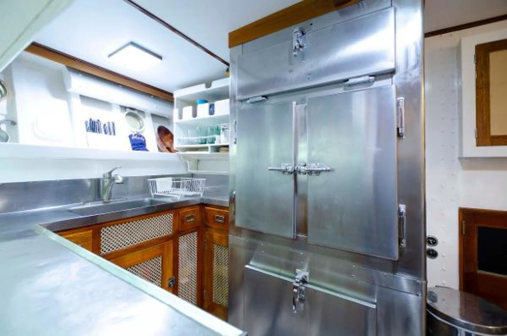 a kitchen with a large stainless steel refrigerator aboard LIBERTY LOVE Yacht for Sale