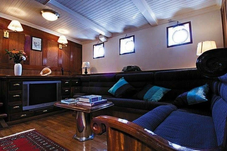 a living room with a couch and a television aboard SEAN PAQUITO IV Yacht for Sale