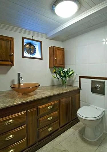 a bathroom with a sink toilet and a mirror aboard SEAN PAQUITO IV Yacht for Sale