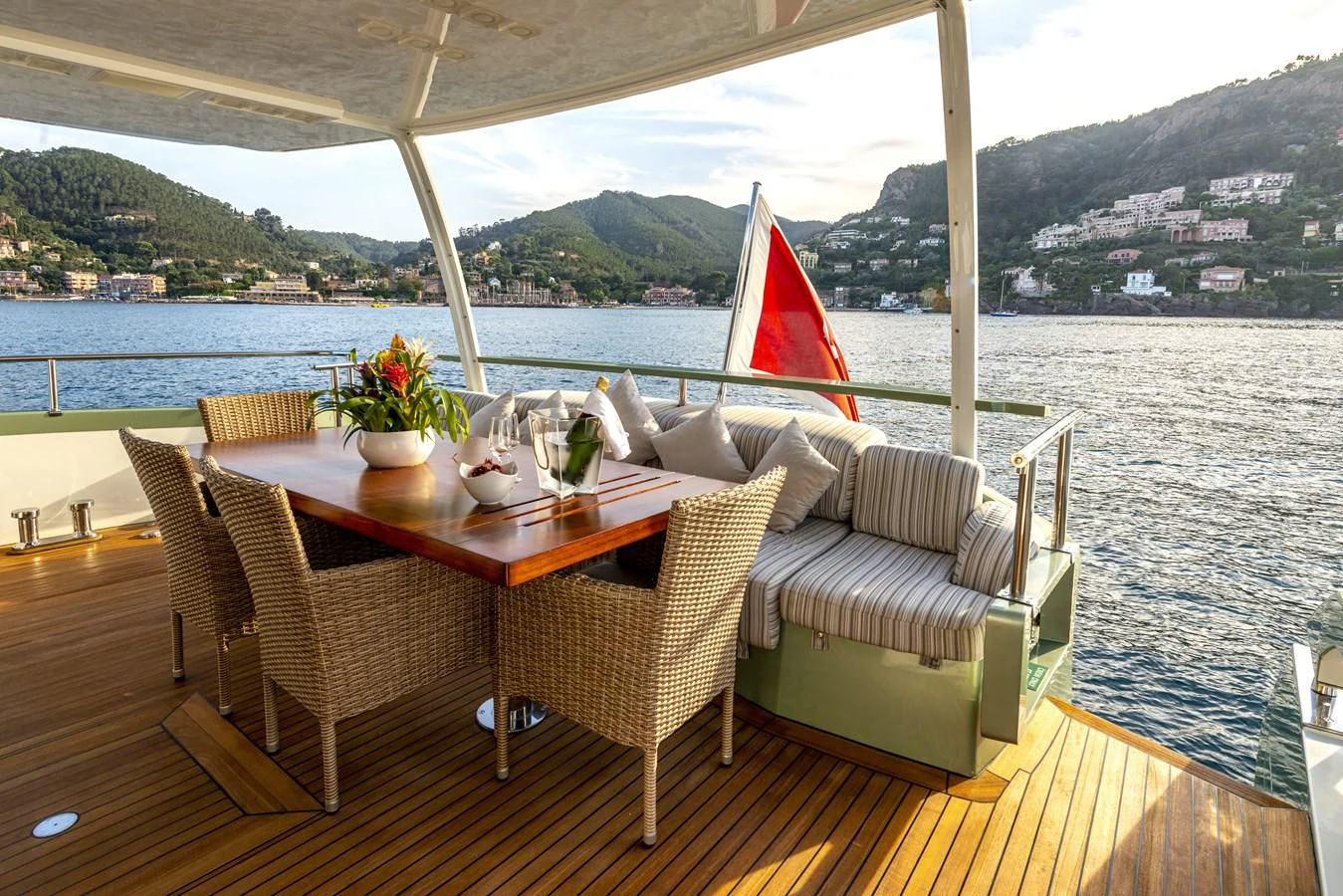 a table with chairs and umbrellas on it by a body of water aboard MANATEA Yacht for Sale