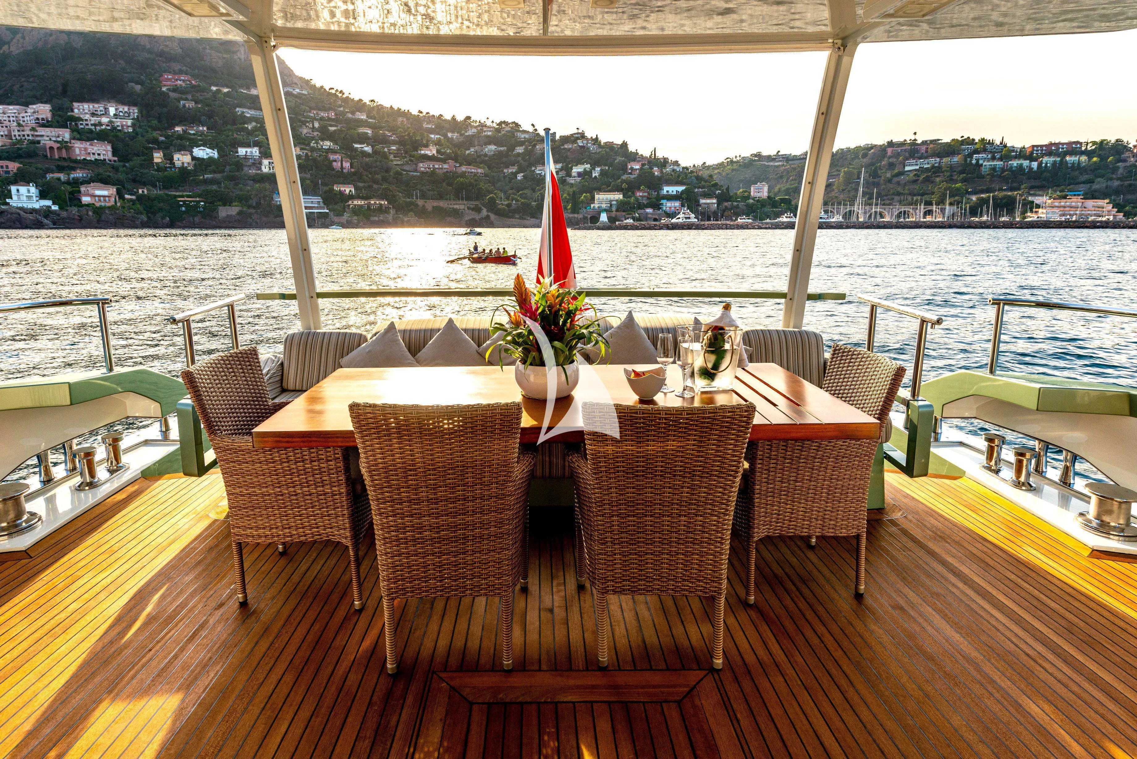 a table with chairs and a plant on it aboard MANATEA Yacht for Sale