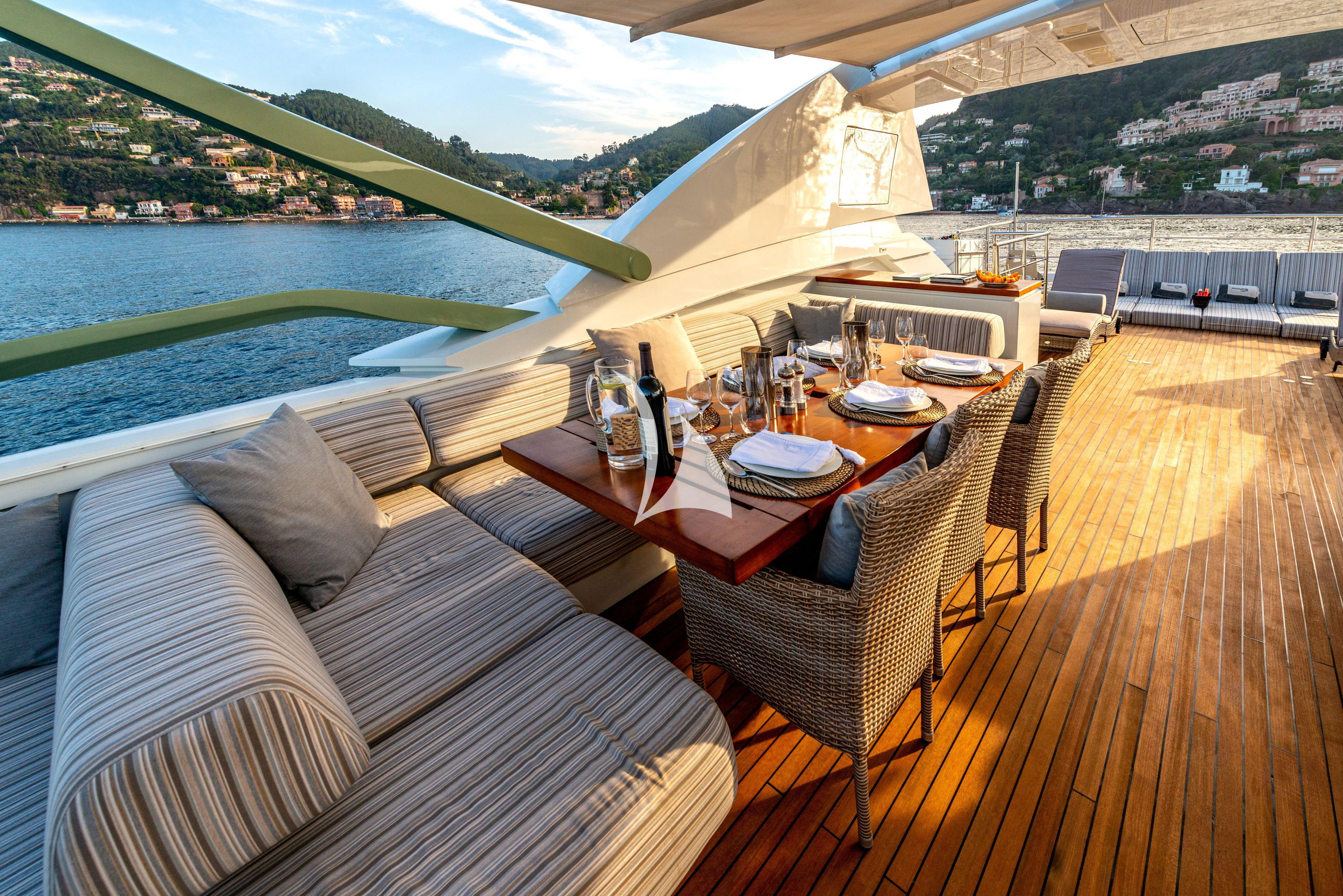 a deck with a table chairs and a pool aboard MANATEA Yacht for Sale
