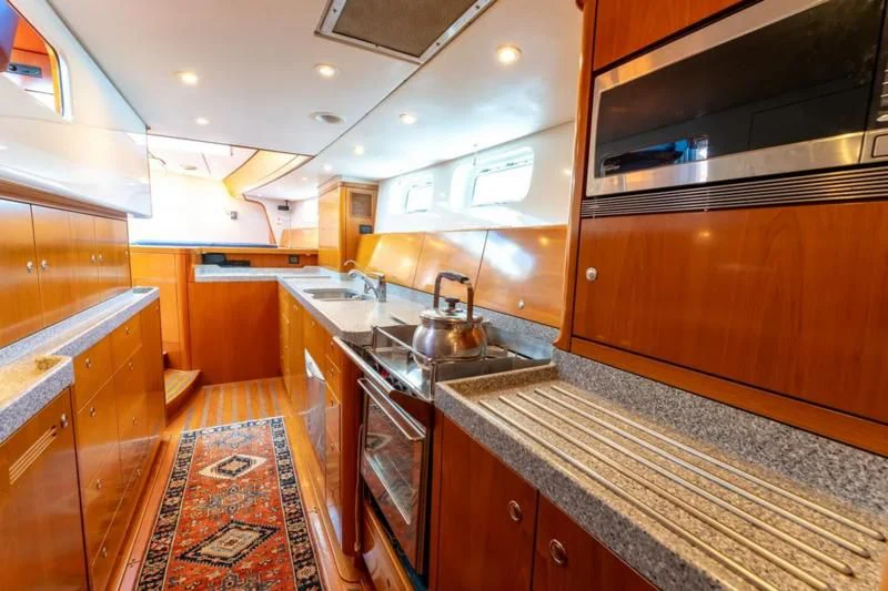 a kitchen with wooden cabinets aboard LEONORE Yacht for Sale