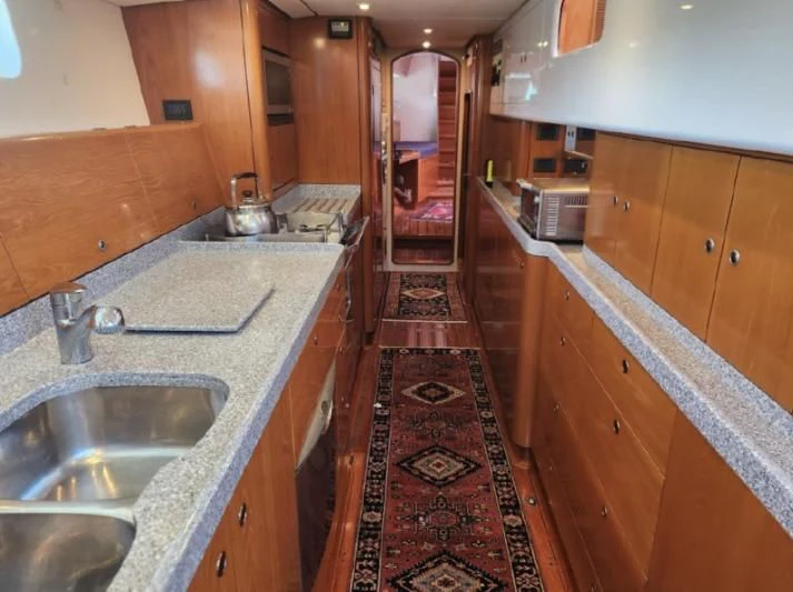 a kitchen with wooden cabinets aboard LEONORE Yacht for Sale