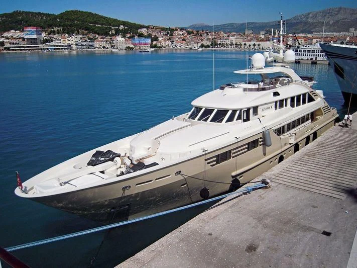 a large white boat docked at a pier aboard MUZA Yacht for Sale