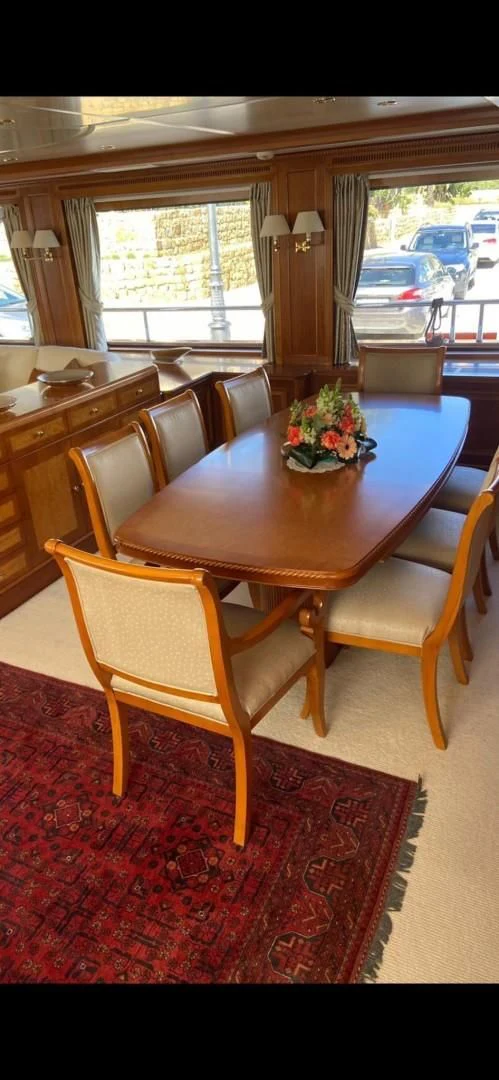 a dining table with chairs and a flower pot on it aboard LA BELLA SARA III Yacht for Sale