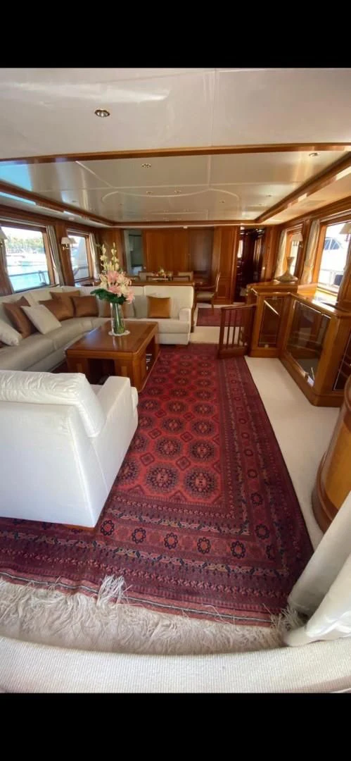 a large living room with a red rug and white couches aboard LA BELLA SARA III Yacht for Sale