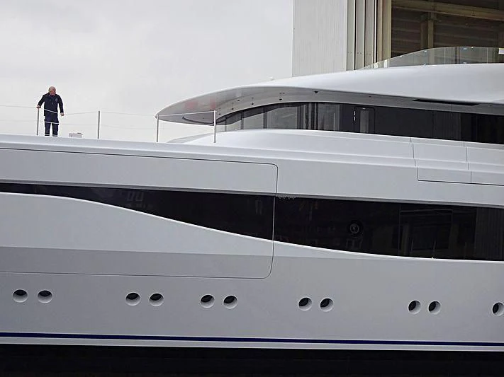 a person standing next to a large yacht aboard ARROW Yacht for Sale