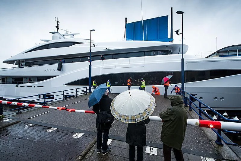people with umbrellas standing on a dock by a boat aboard ARROW Yacht for Sale