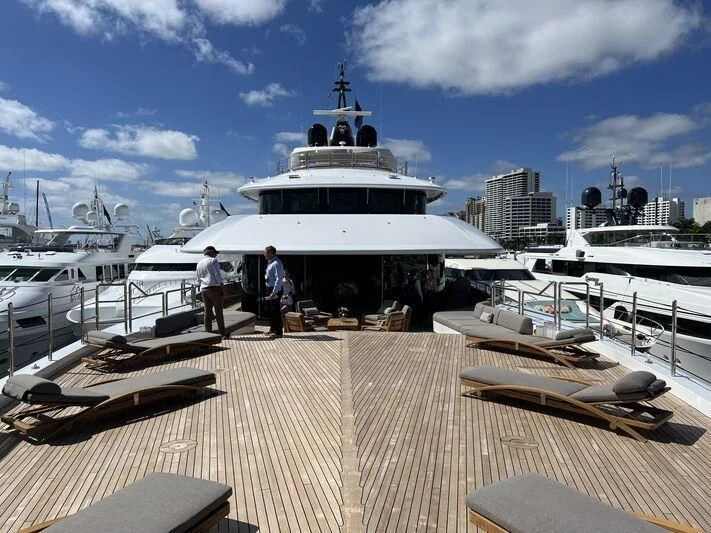 a group of people walking on a dock next to a large white boat aboard ARROW Yacht for Sale