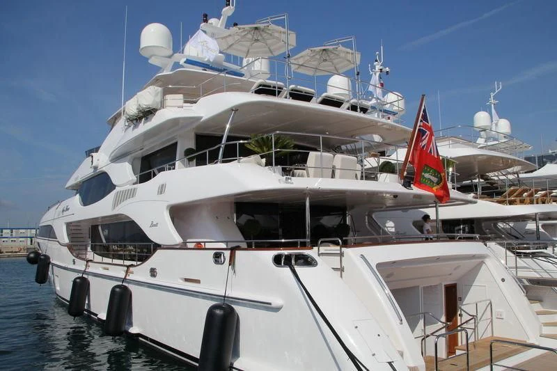 a large white boat with a red and black stripe on it aboard NELA Yacht for Charter