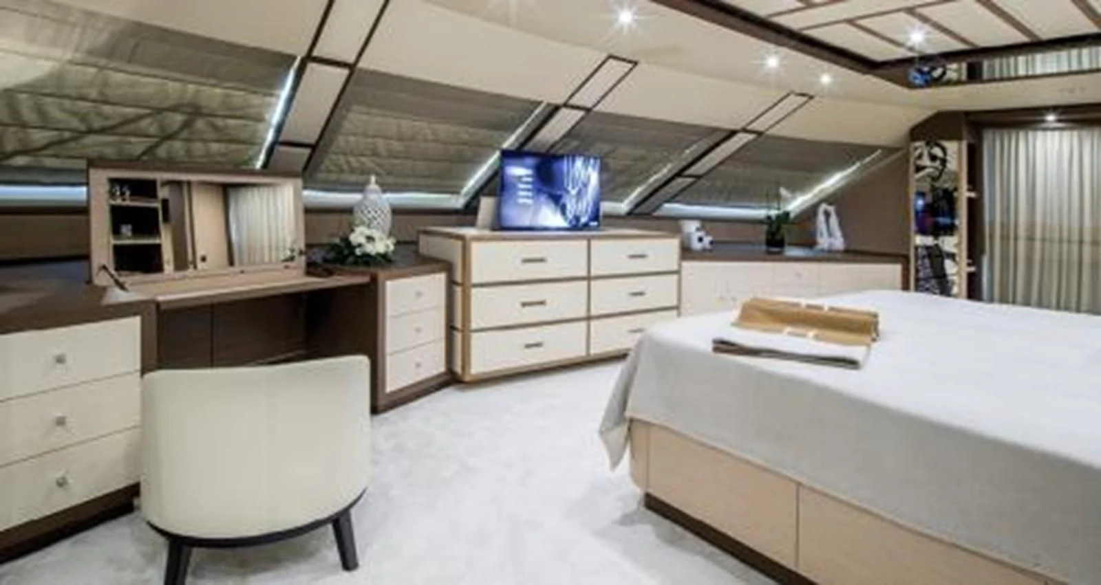 a room with a bed and a chair aboard NELA Yacht for Charter