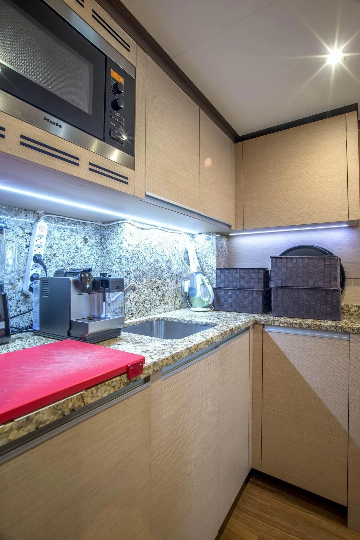 a kitchen with a microwave oven and a sink aboard NELA Yacht for Charter