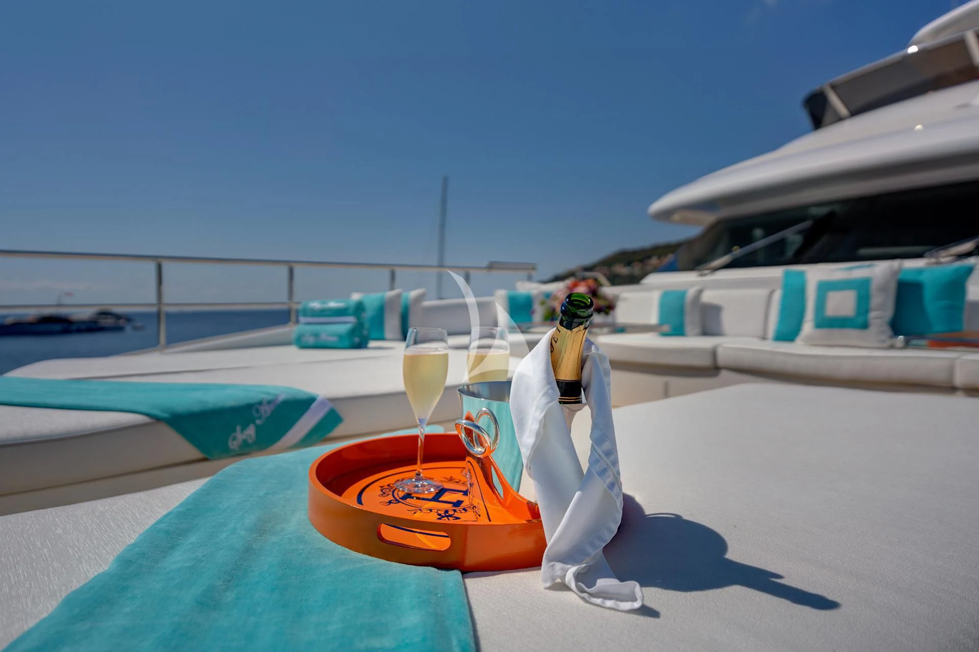 a person on a surfboard next to a glass of wine aboard NELA Yacht for Charter