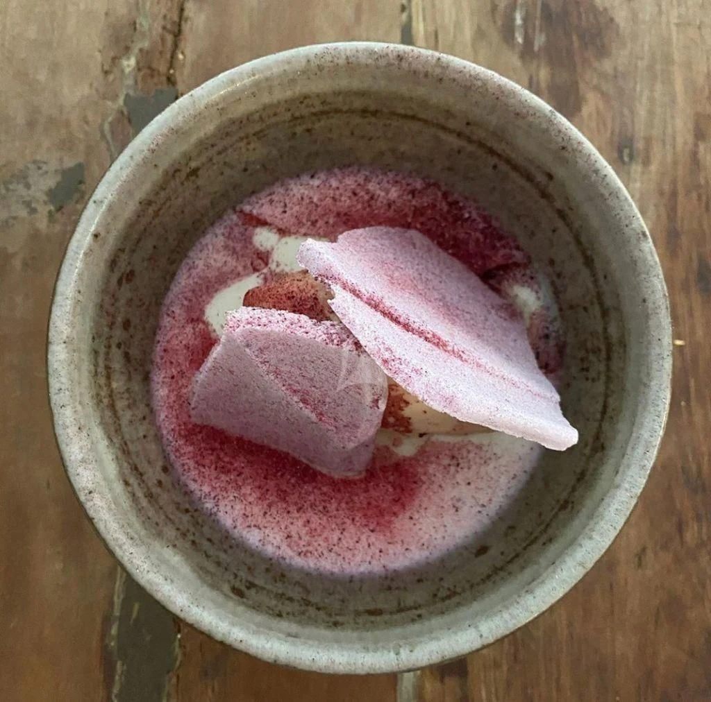 a cup of liquid with a slice of meat on top aboard NELA Yacht for Charter