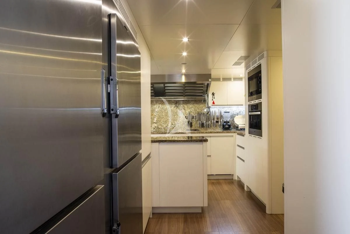 a kitchen with a stainless steel refrigerator aboard NELA Yacht for Charter
