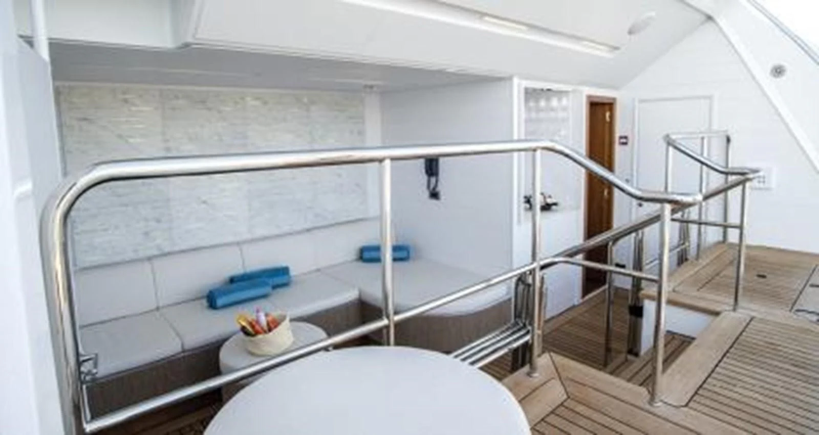 a white room with a bed and a table aboard NELA Yacht for Charter