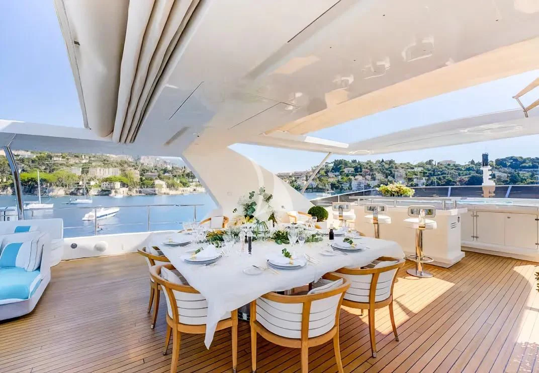 a room with tables and chairs aboard NELA Yacht for Charter