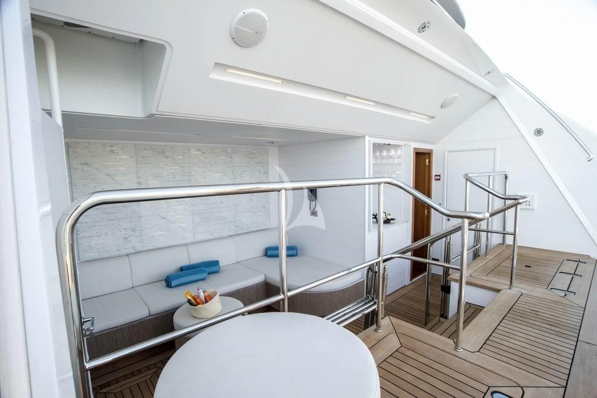 a white room with a bed and a table aboard NELA Yacht for Charter