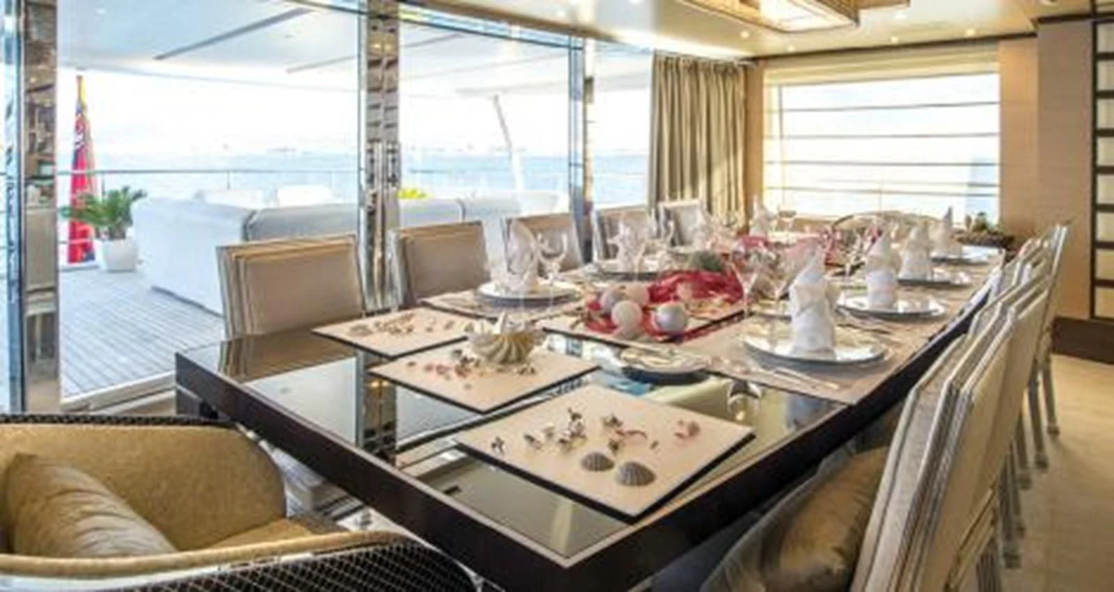 a dining table with a large window aboard NELA Yacht for Charter