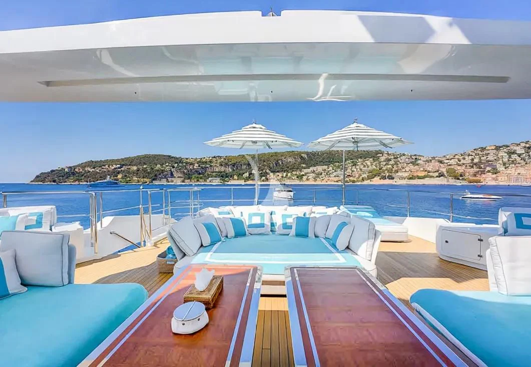 a pool with lounge chairs and umbrellas aboard NELA Yacht for Charter