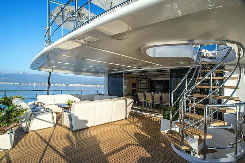 a room with a balcony and a large balcony aboard NELA Yacht for Charter