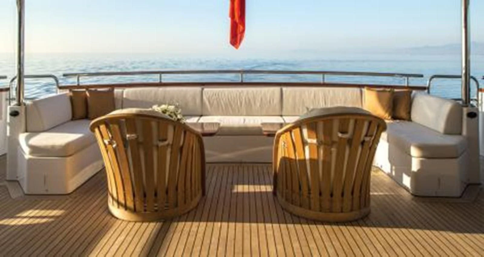 a deck with chairs and a table on it aboard NELA Yacht for Charter