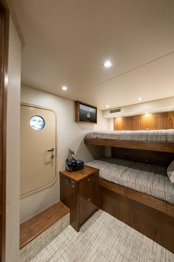 a bedroom with a bed and a tv on the wall aboard IT JUST TAKES TIME Yacht for Sale