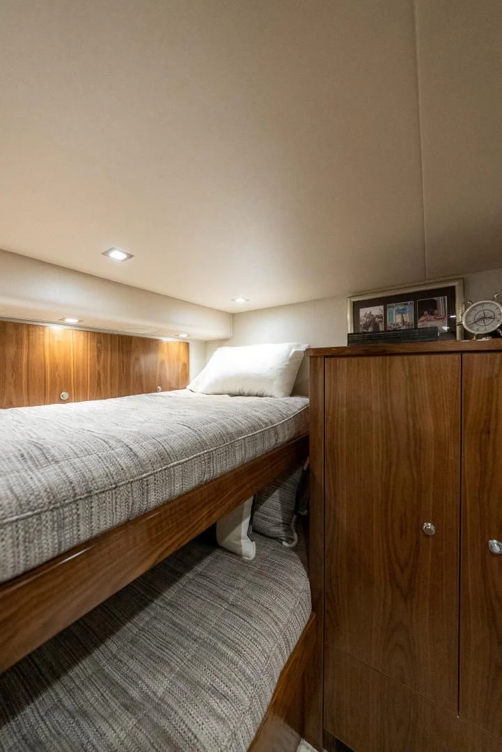 a room with a bed and a wood cabinet aboard IT JUST TAKES TIME Yacht for Sale