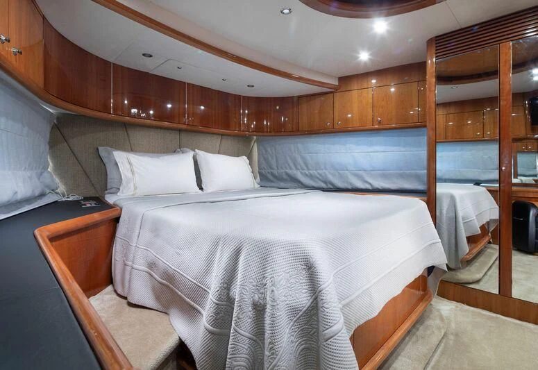 a bed with a white sheet and a wooden headboard aboard SPACE ODDITY Yacht for Sale