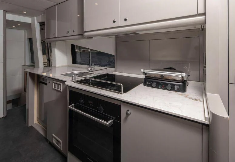 a kitchen with white cabinets aboard SPACE ODDITY Yacht for Sale
