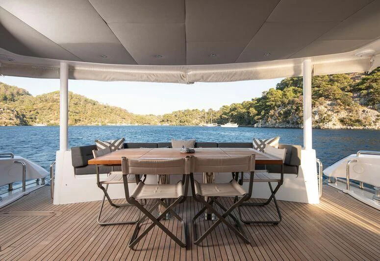 a table and chairs on a deck aboard SPACE ODDITY Yacht for Sale