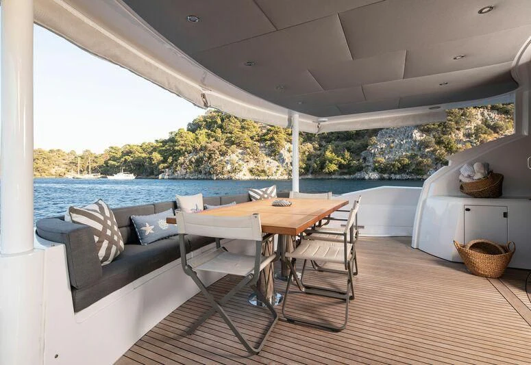 a table and chairs on a deck aboard SPACE ODDITY Yacht for Sale