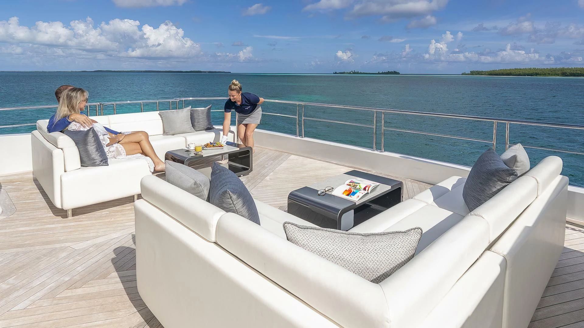 a group of people sitting on a couch looking at a body of water aboard ENTREPRENEUR Yacht for Charter