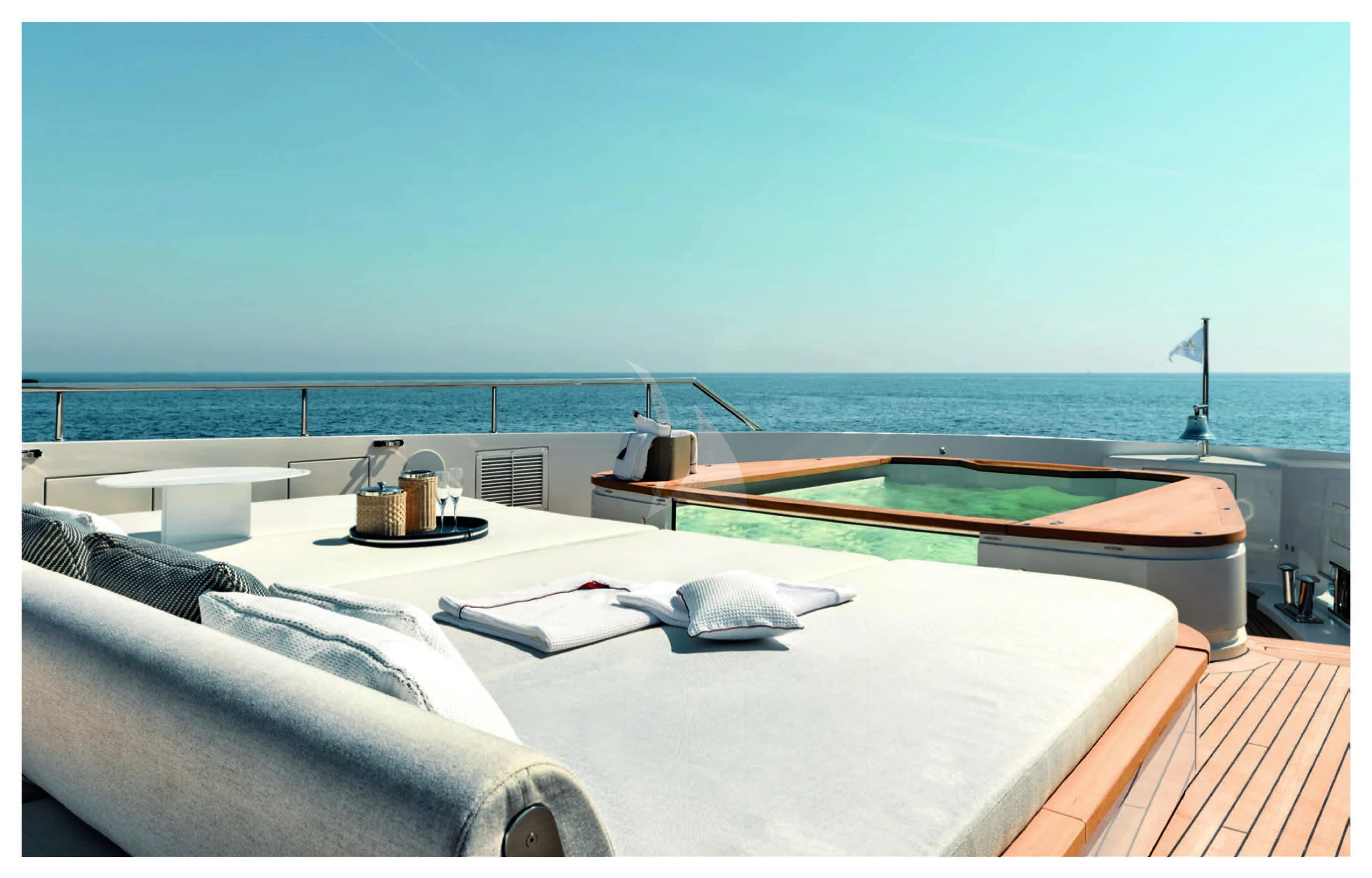 a bed with a pool table and a pool in the background aboard HAYAT Yacht for Sale