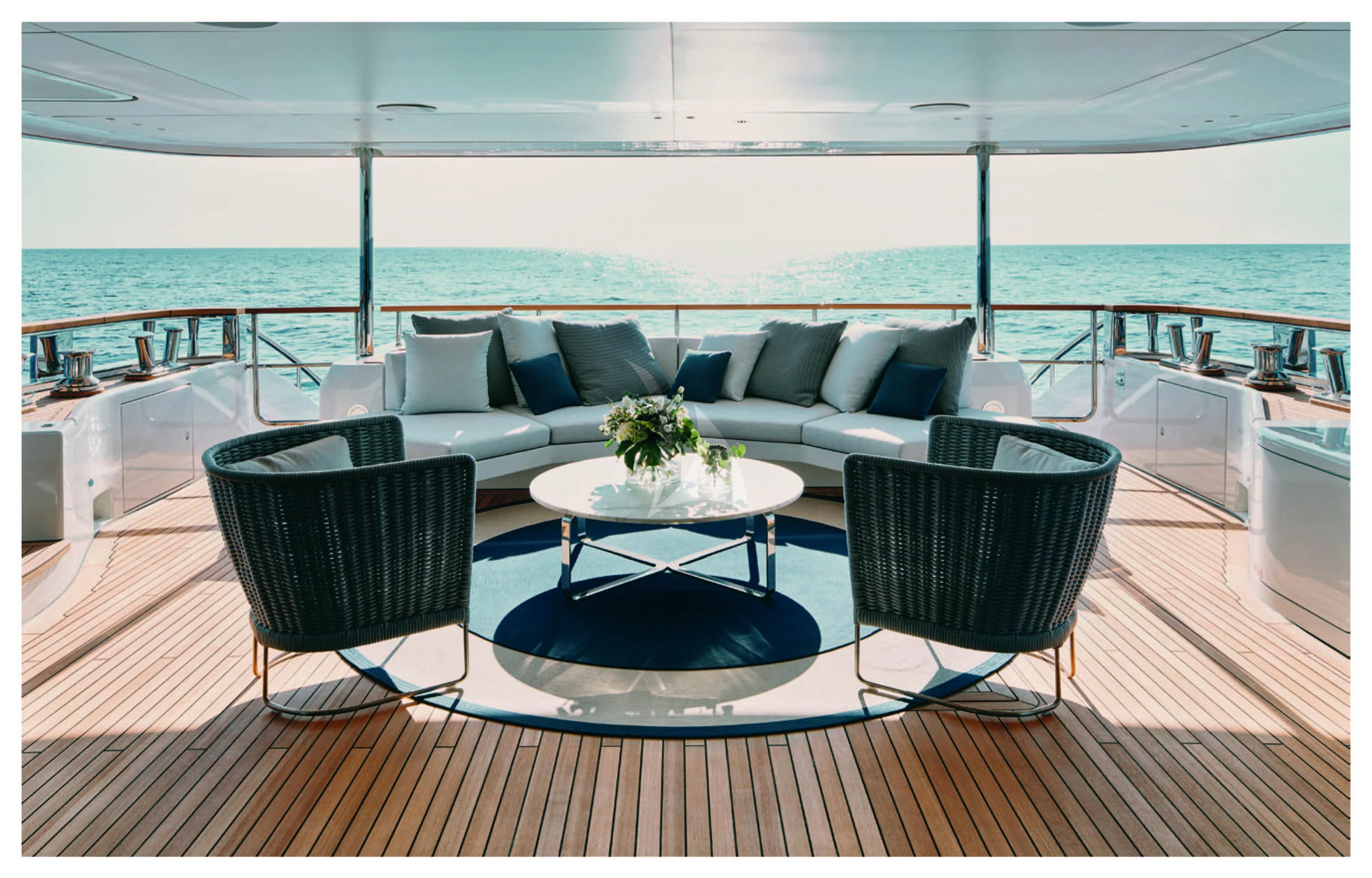 a couch and chairs on a deck overlooking a body of water aboard HAYAT Yacht for Sale