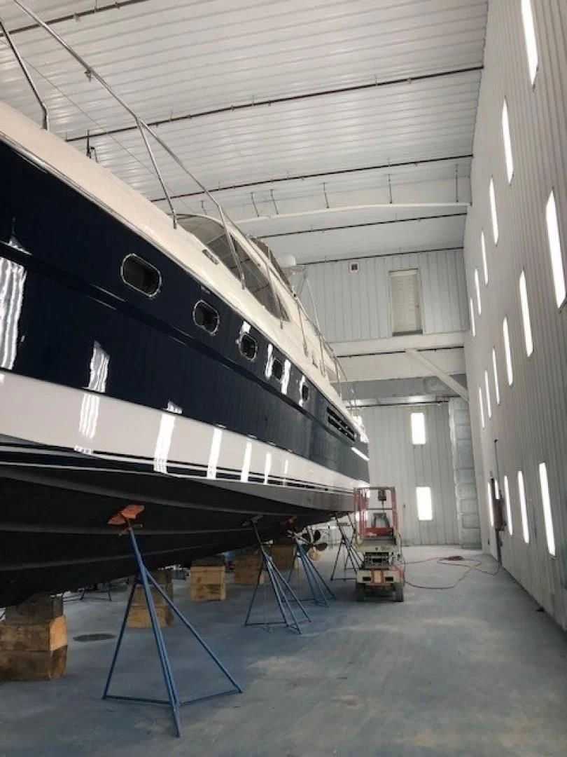 a large white boat in a warehouse aboard JOIE DU ROI Yacht for Sale