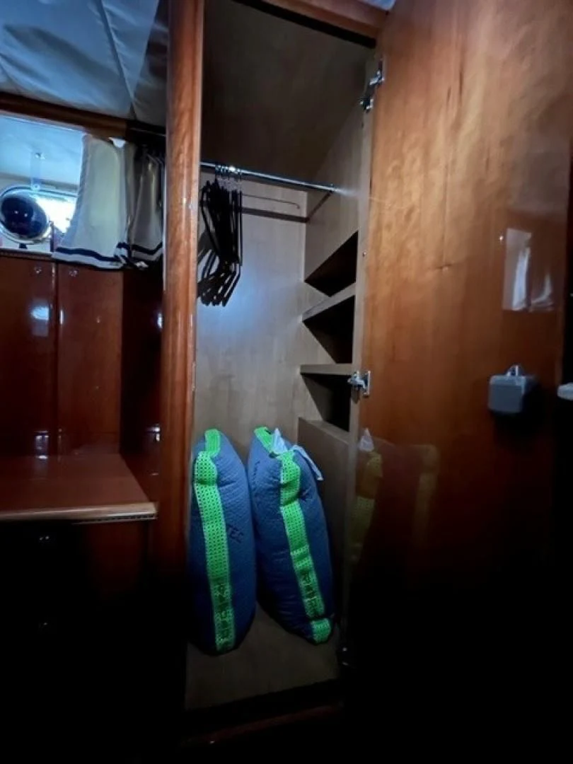 a closet with clothes on the wall aboard JOIE DU ROI Yacht for Sale