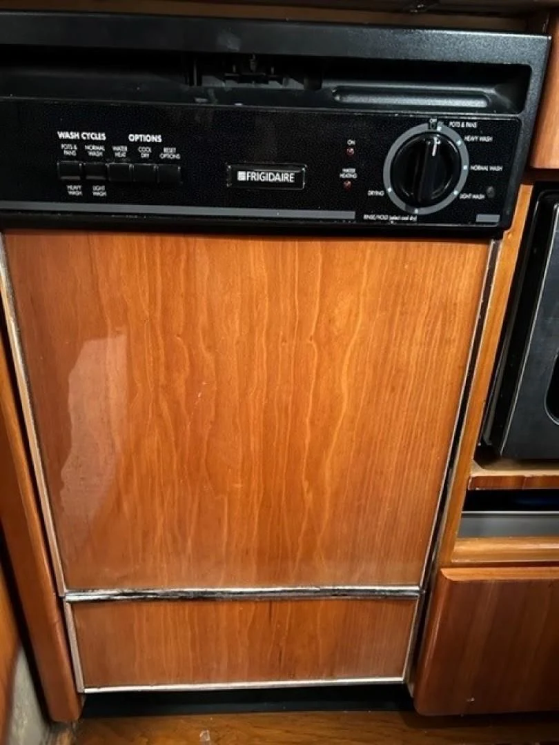 a wooden cabinet with a black microwave aboard JOIE DU ROI Yacht for Sale