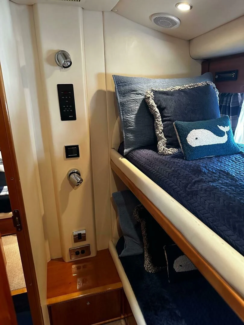 a bed with a blue comforter aboard JOIE DU ROI Yacht for Sale