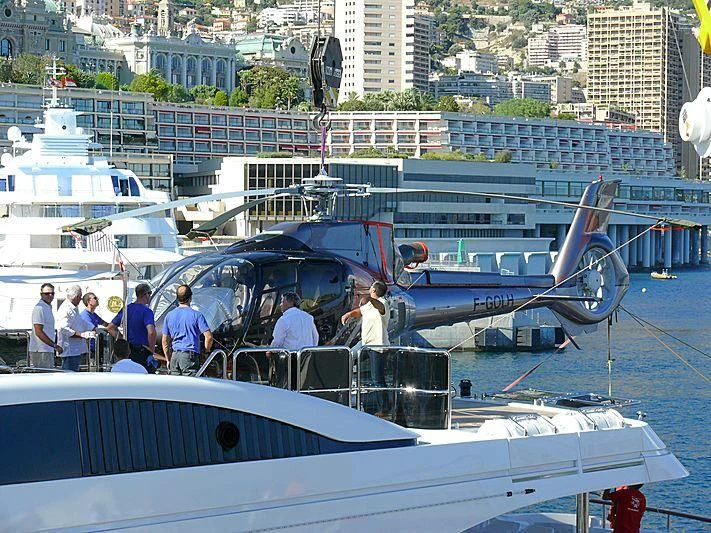 a group of people standing next to a plane on a dock aboard GALKYNYS Yacht for Sale