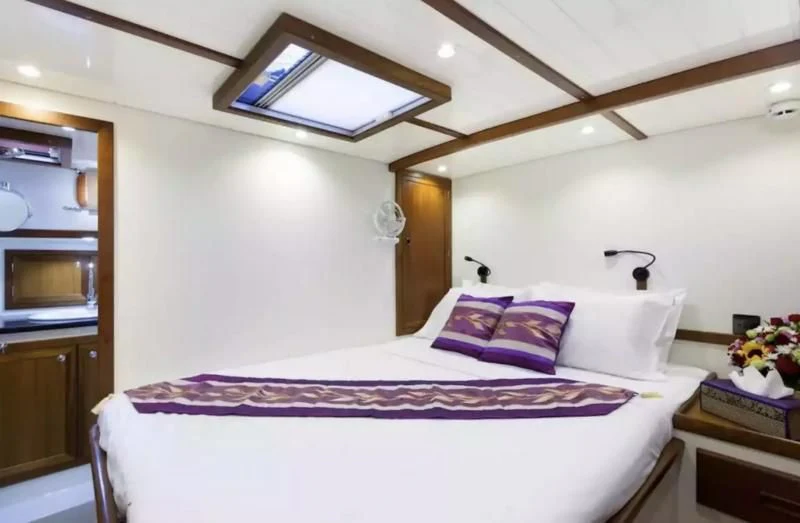 a bed with purple sheets aboard DALLINGHOO Yacht for Sale