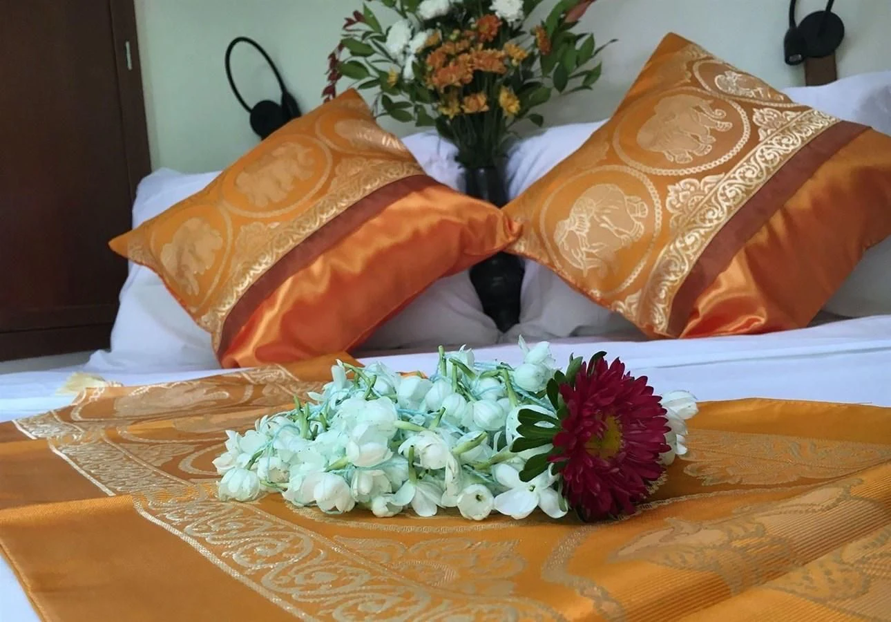 a bed with a flower and pillows aboard DALLINGHOO Yacht for Sale