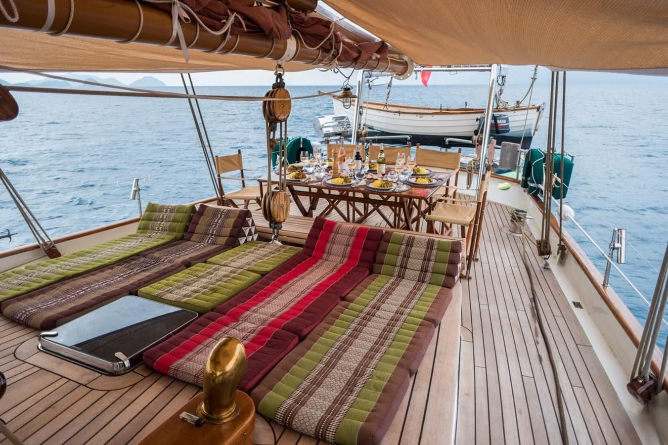 a deck with a table and chairs on it aboard DALLINGHOO Yacht for Sale