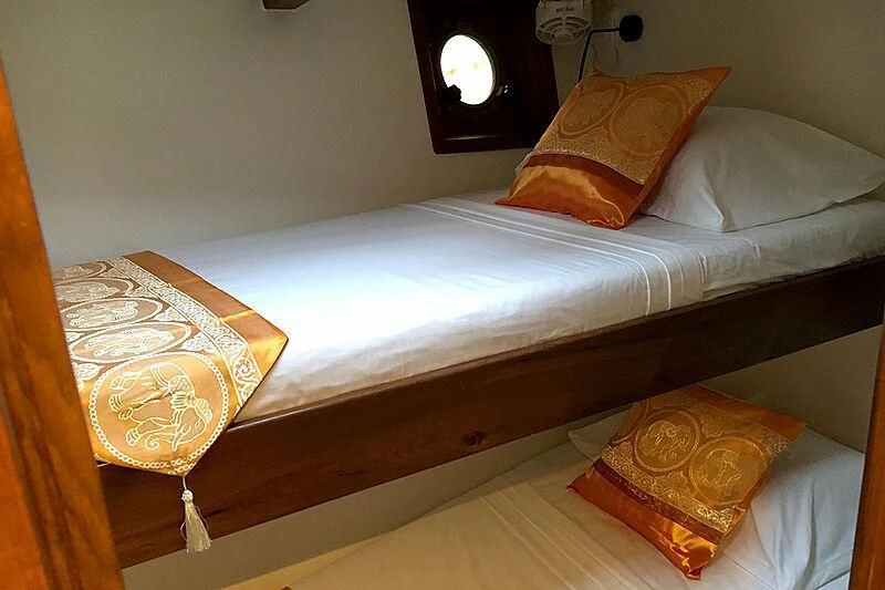 a bed with a white sheet and pillows aboard DALLINGHOO Yacht for Sale