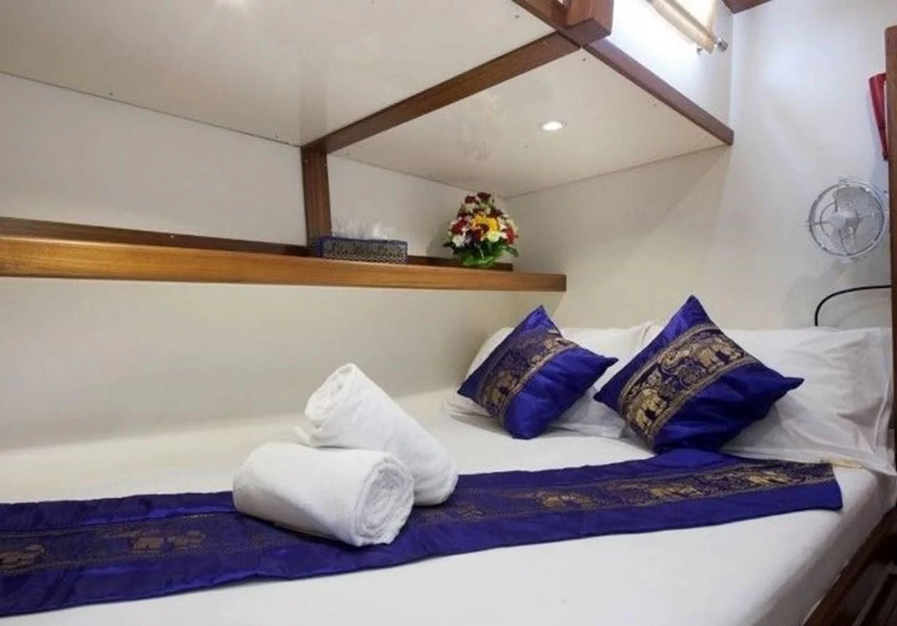 a bed with blue sheets and pillows aboard DALLINGHOO Yacht for Sale