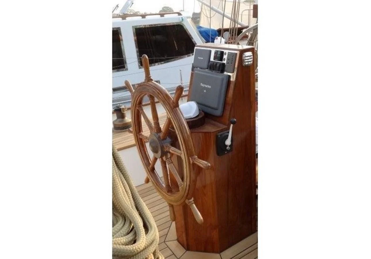 a wooden boat with a wheel aboard DALLINGHOO Yacht for Sale