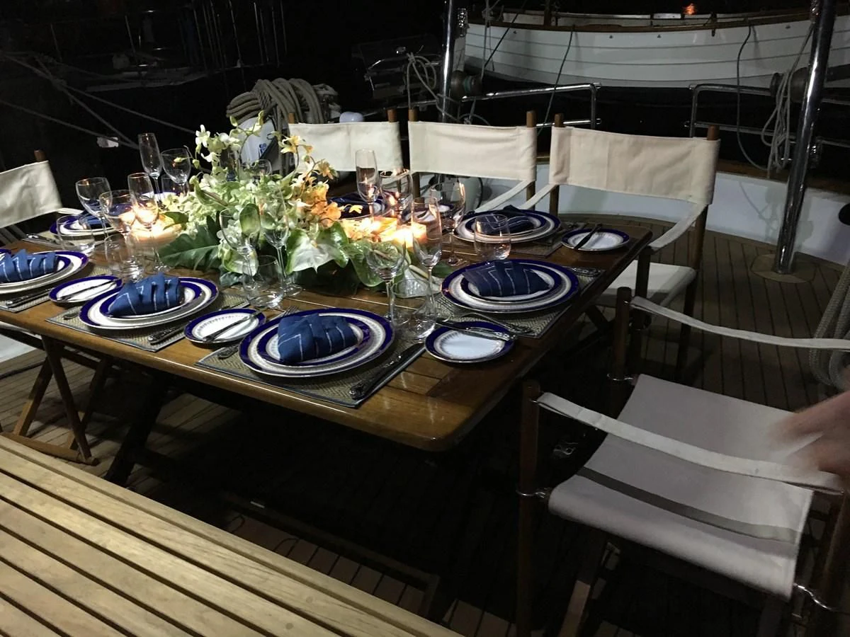a table set with plates and glasses aboard DALLINGHOO Yacht for Sale