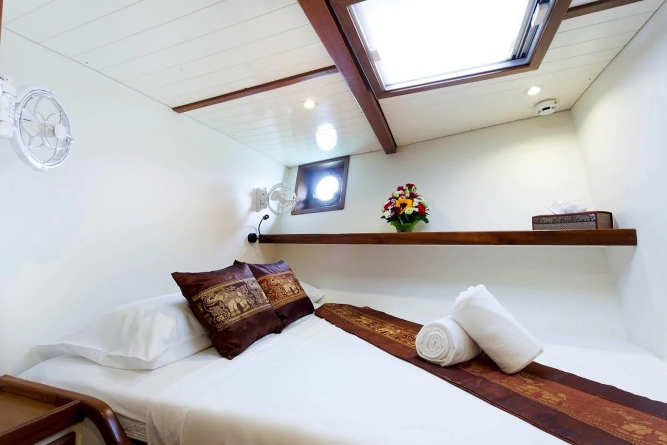 a bed with a flowered pillow aboard DALLINGHOO Yacht for Sale