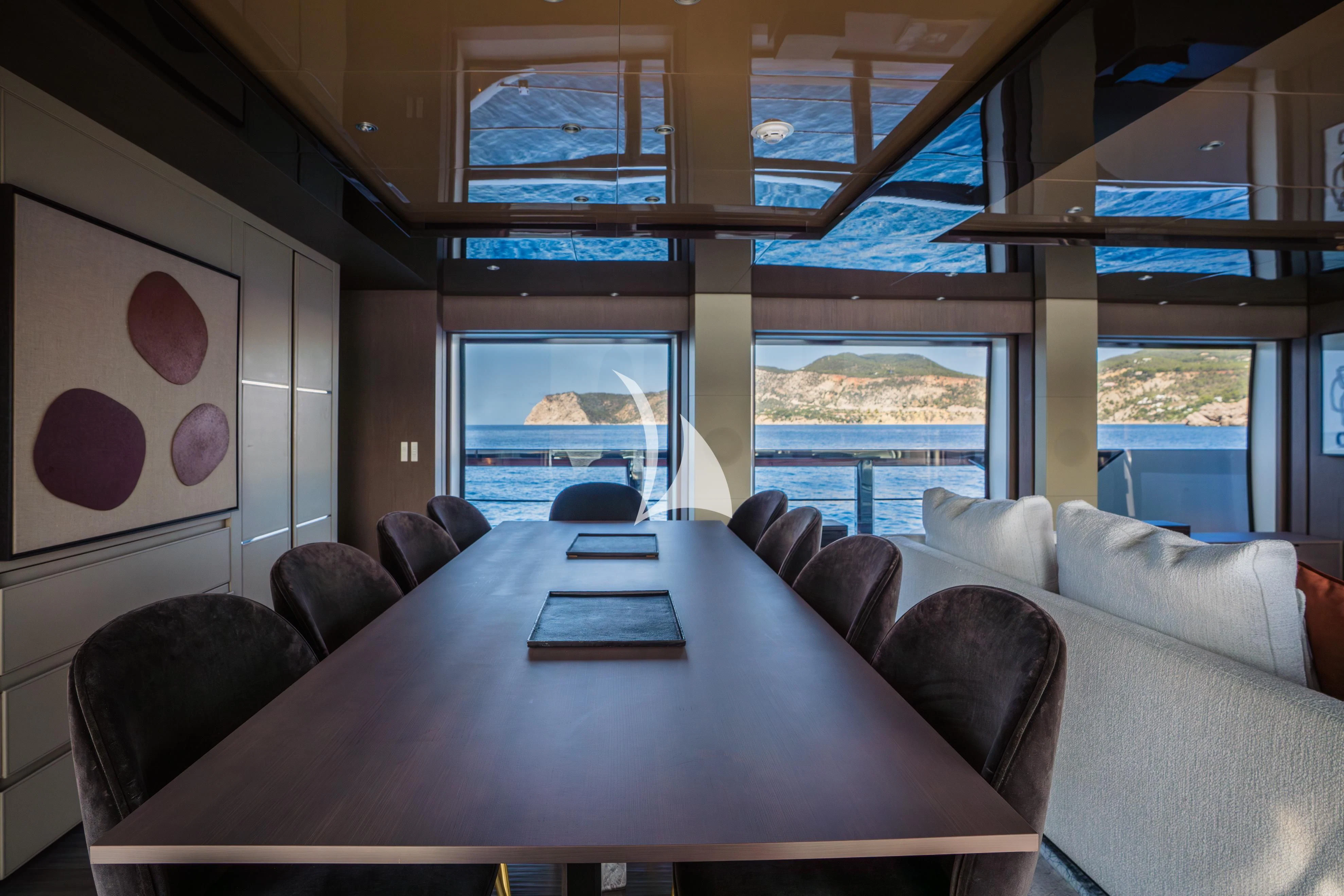 a room with a table and couches aboard ALVIUM Yacht for Sale